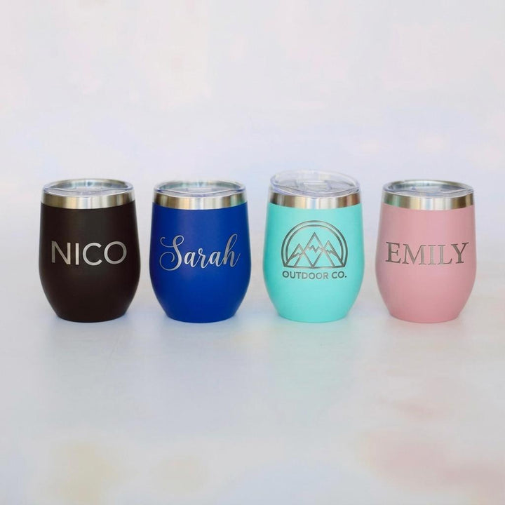 Four personalized tumblers in different colors with names engraved on them. Etch 'N' Shine
