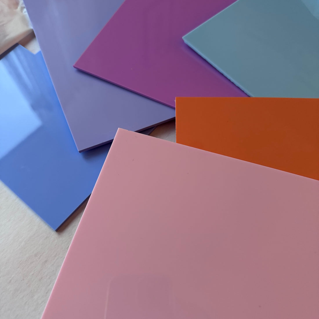 Pastel acrylic sheets fanned out in cool tones – purple, lilac, blue and pink – laser engraving material for cupcake charms and signs – Etch 'N' Shine