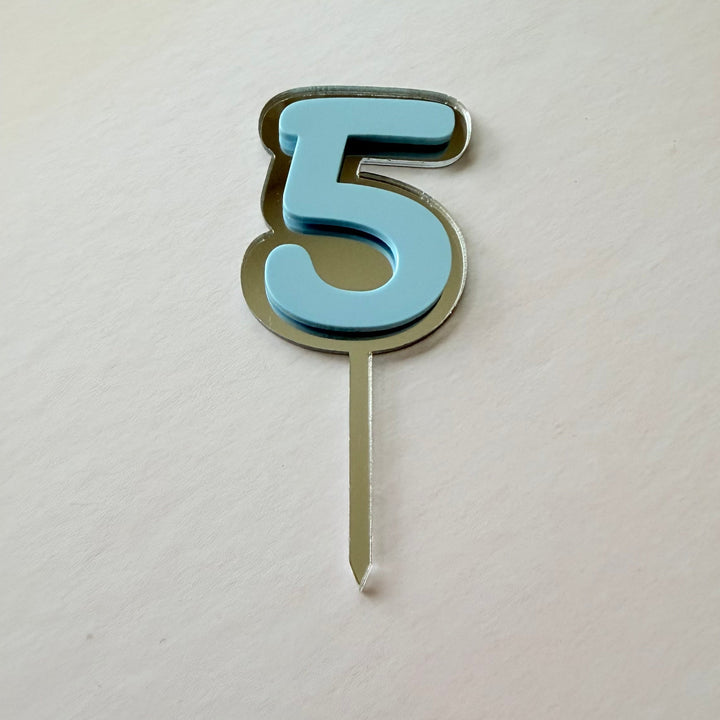 Blue mirror and acrylic double layer number 2 cake topper in a flat lay