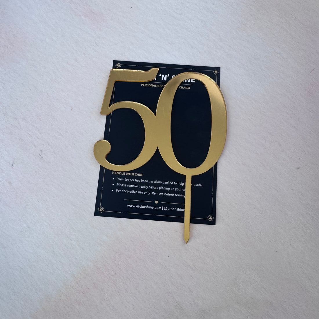 Gold mirror acrylic number 50 cake topper in presentation packaging