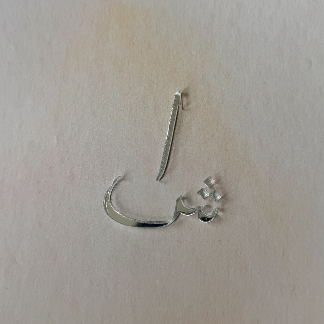 A silver-toned metal nose hoop earring with a small cluster of clear rhinestones on one end, shown on a plain off-white background.