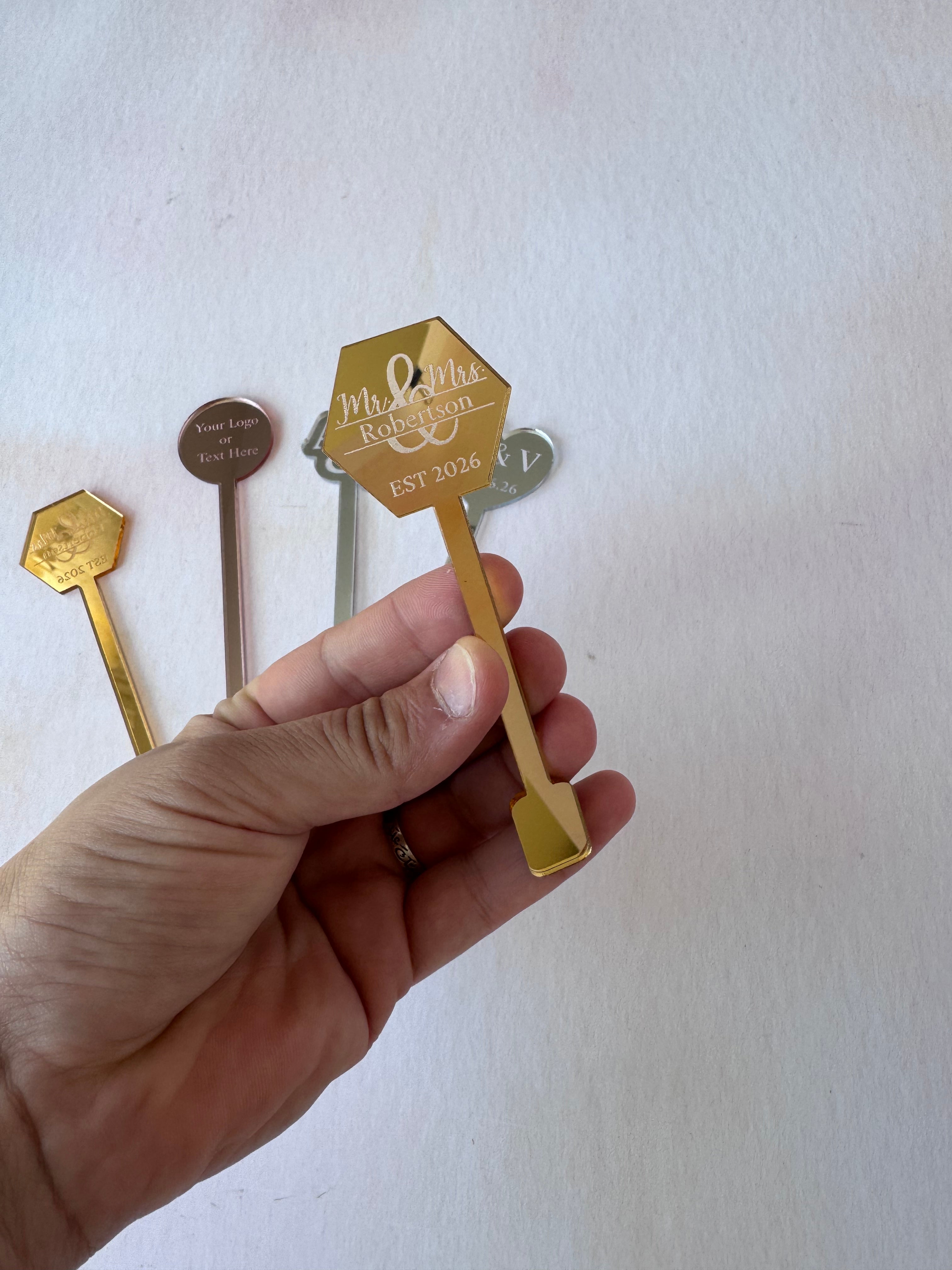 Gold mirror acrylic drink stirrers engraved Mr and Mrs Est 2026 held in hand – Etch 'N' Shine