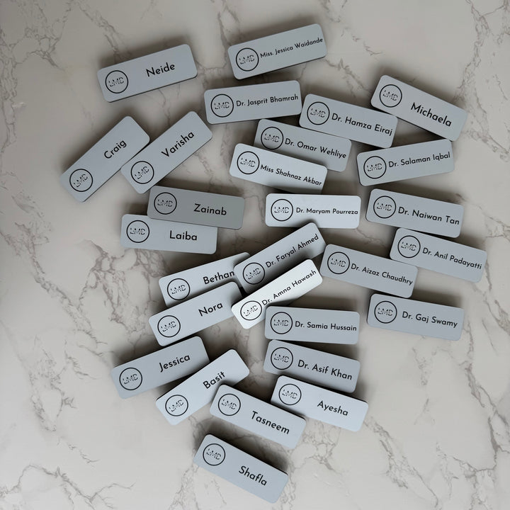 Set of name tags with various names on a marble surface