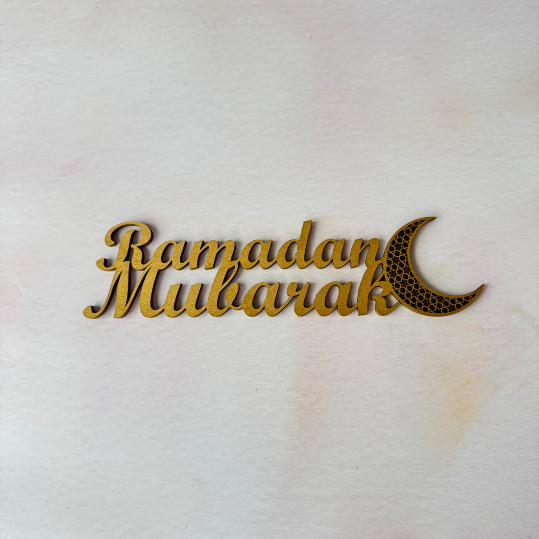 Decorative sign with 'Ramadan Mubarak' text and moon symbol on a white background