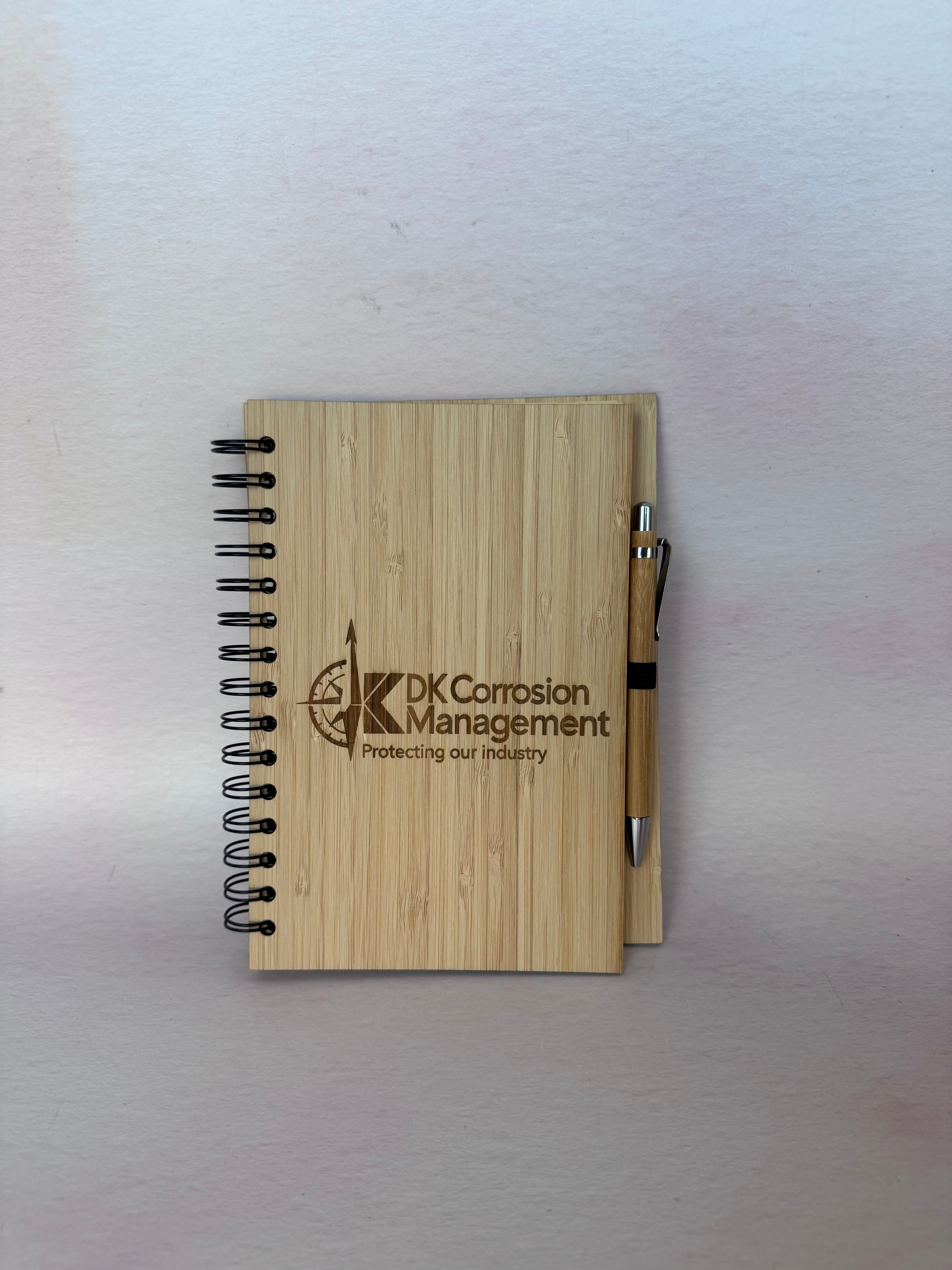 Bamboo spiral notebook with pen engraved with the DK Corrosion Management logo – Etch 'N' Shine