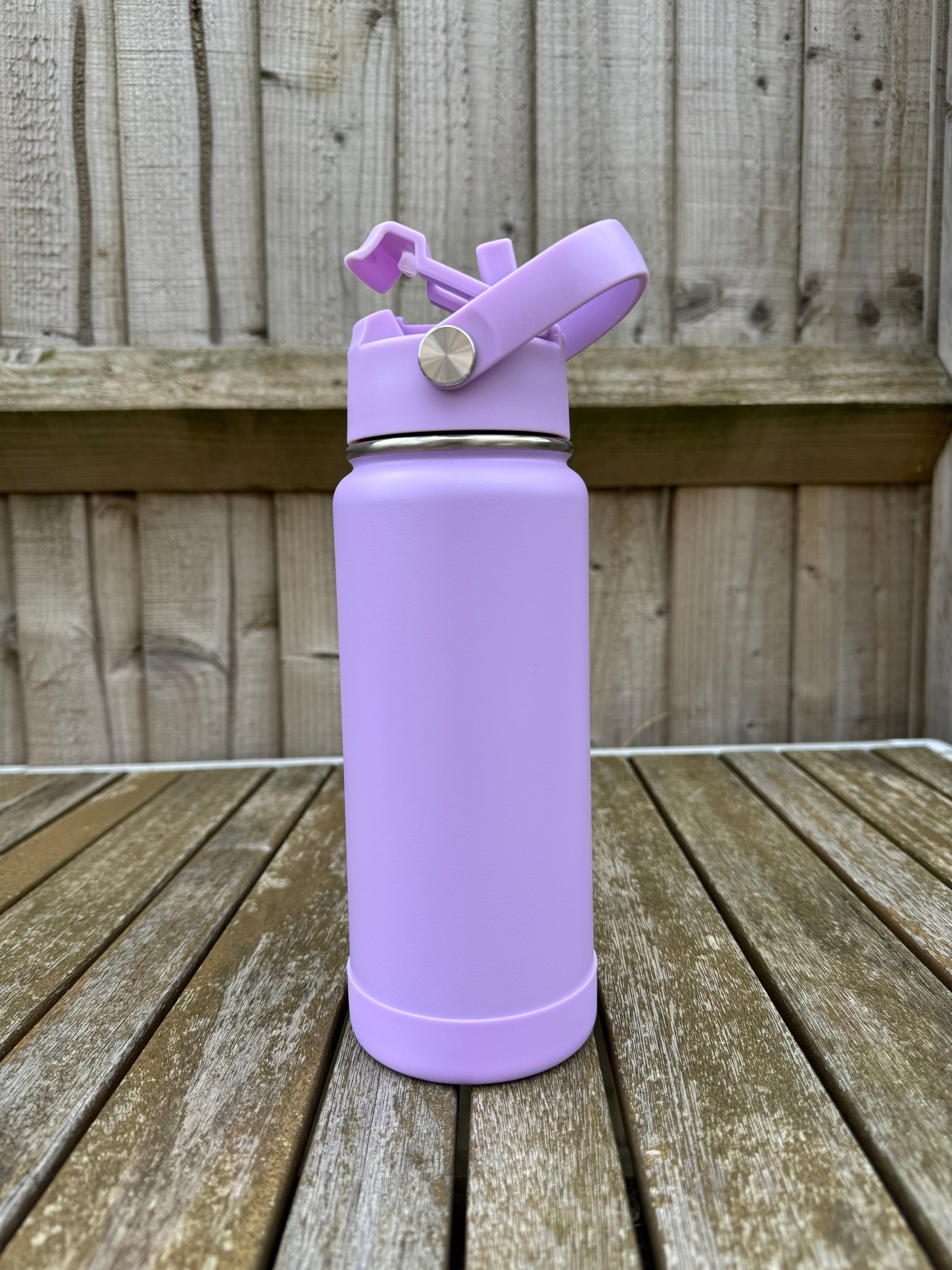 Purple water bottle with a straw on a wooden surface