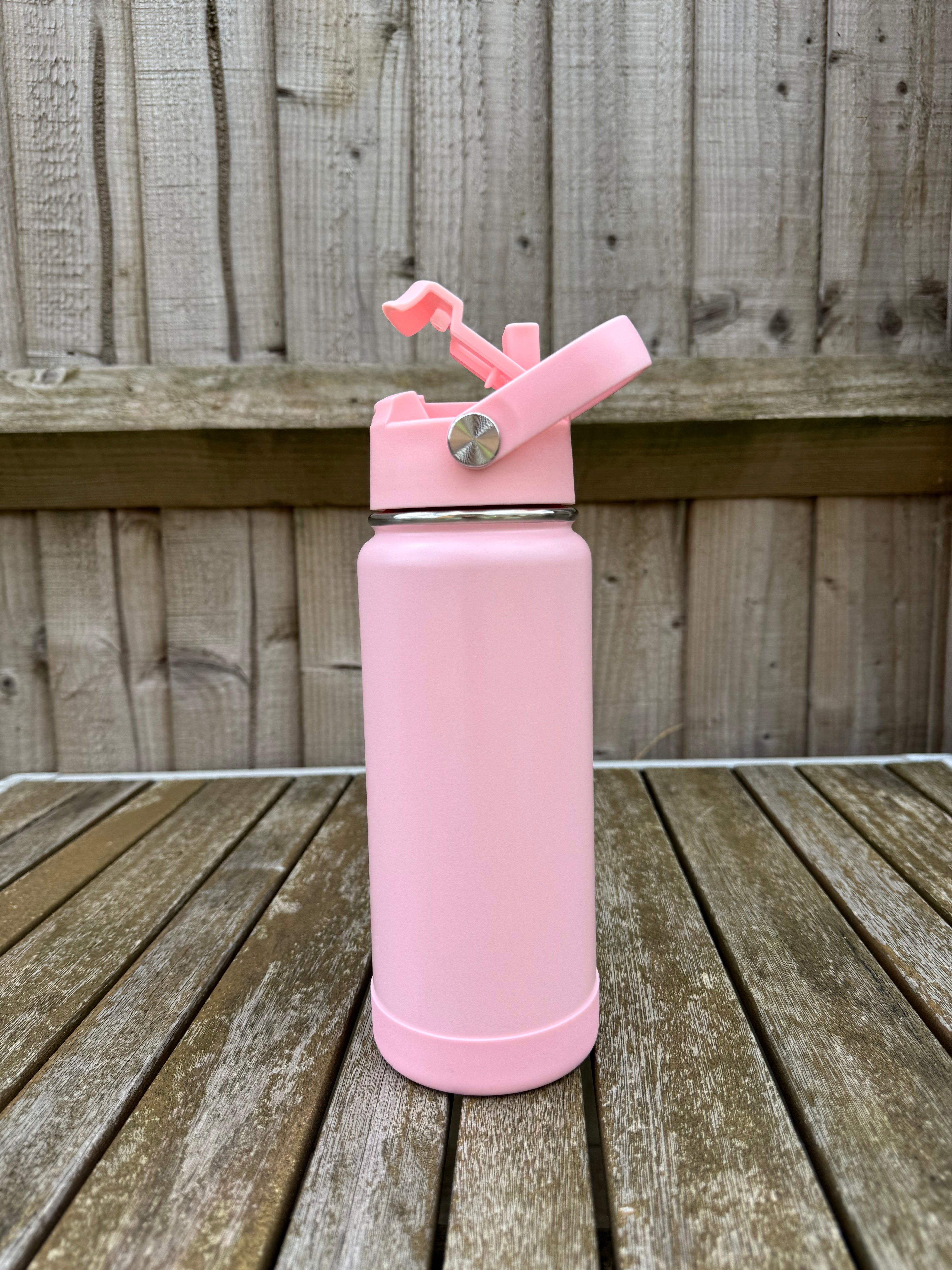 Pink pastel water bottle on a wooden surface