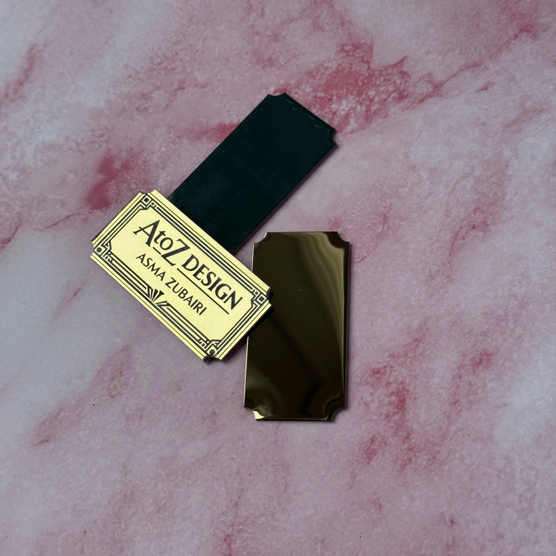 Black product with gold label on a pink marble background