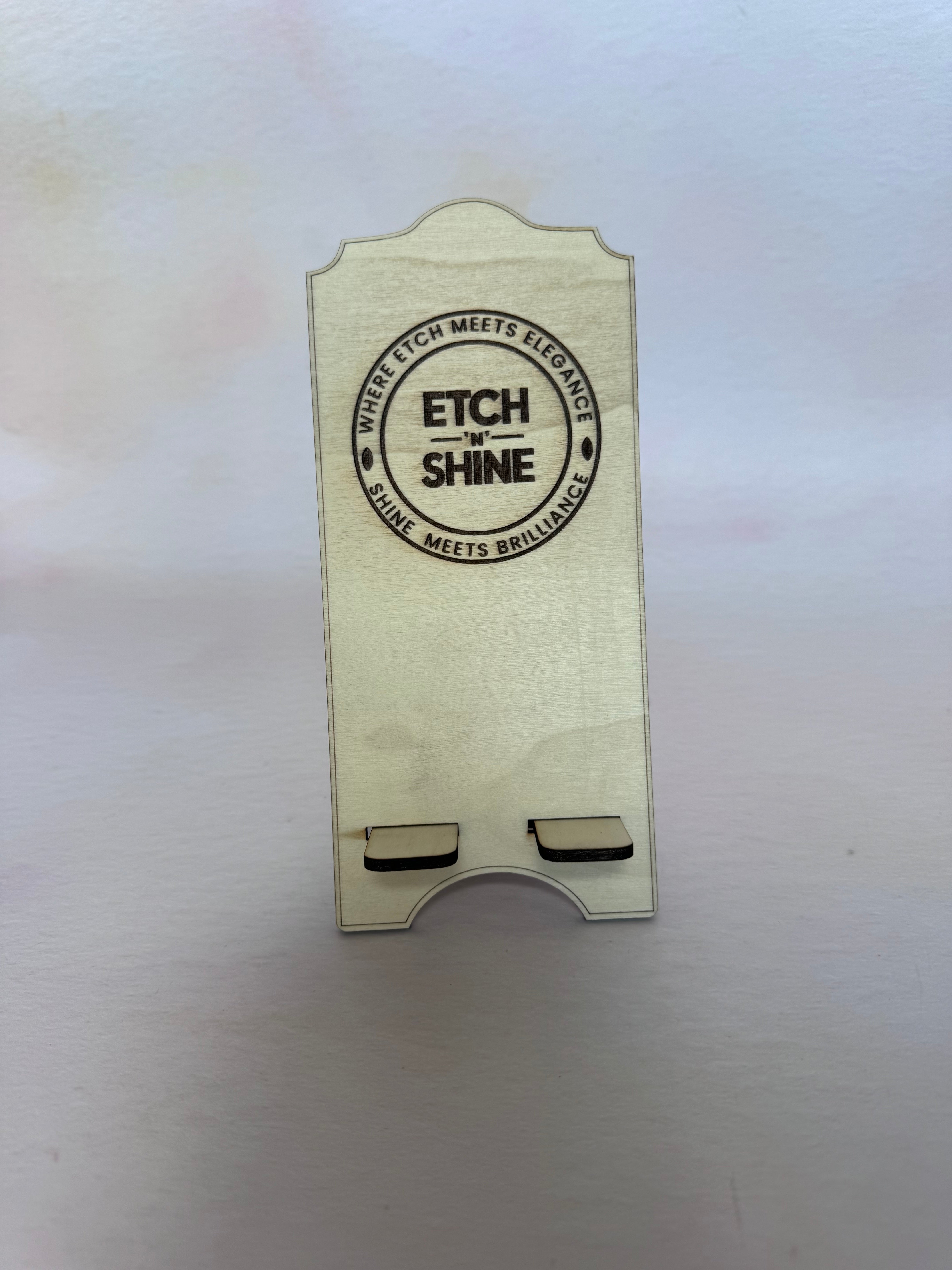 Front of a birch plywood phone stand with an engraved circular logo – Etch 'N' Shine