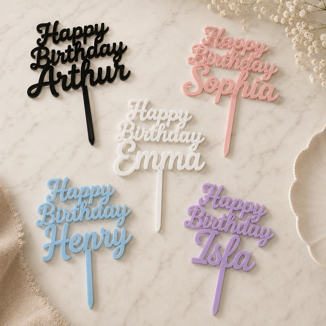 Personalized 'Happy Birthday' cake toppers in various colors on a marble surface.