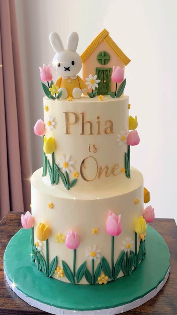 Personalised gold acrylic topper and charm set displayed on a birthday cake