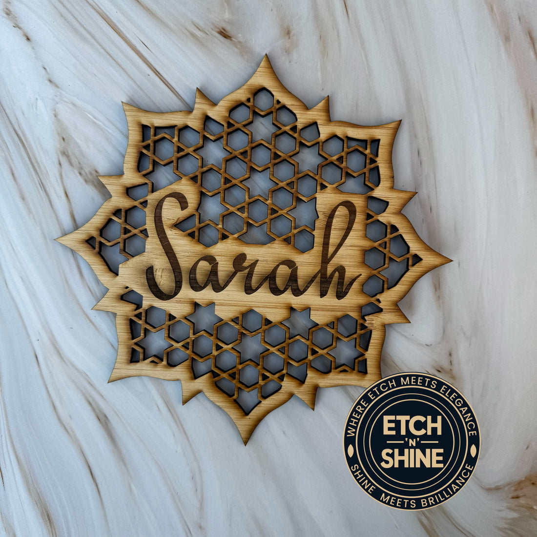 Wooden decorative item with 'Sarah' engraved on a marble surface, featuring the brand 'Etch n Shine'.