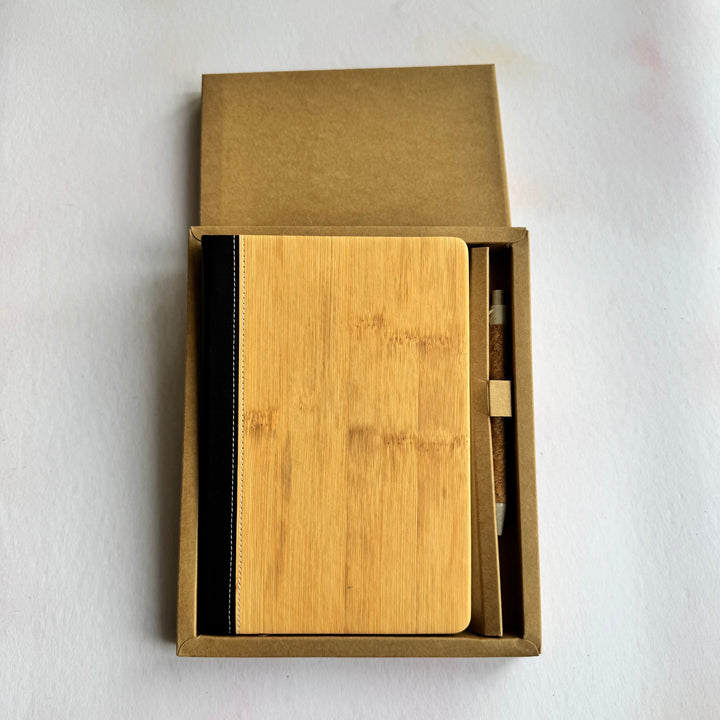 Wooden notebook and pen set in a cardboard box on a white background