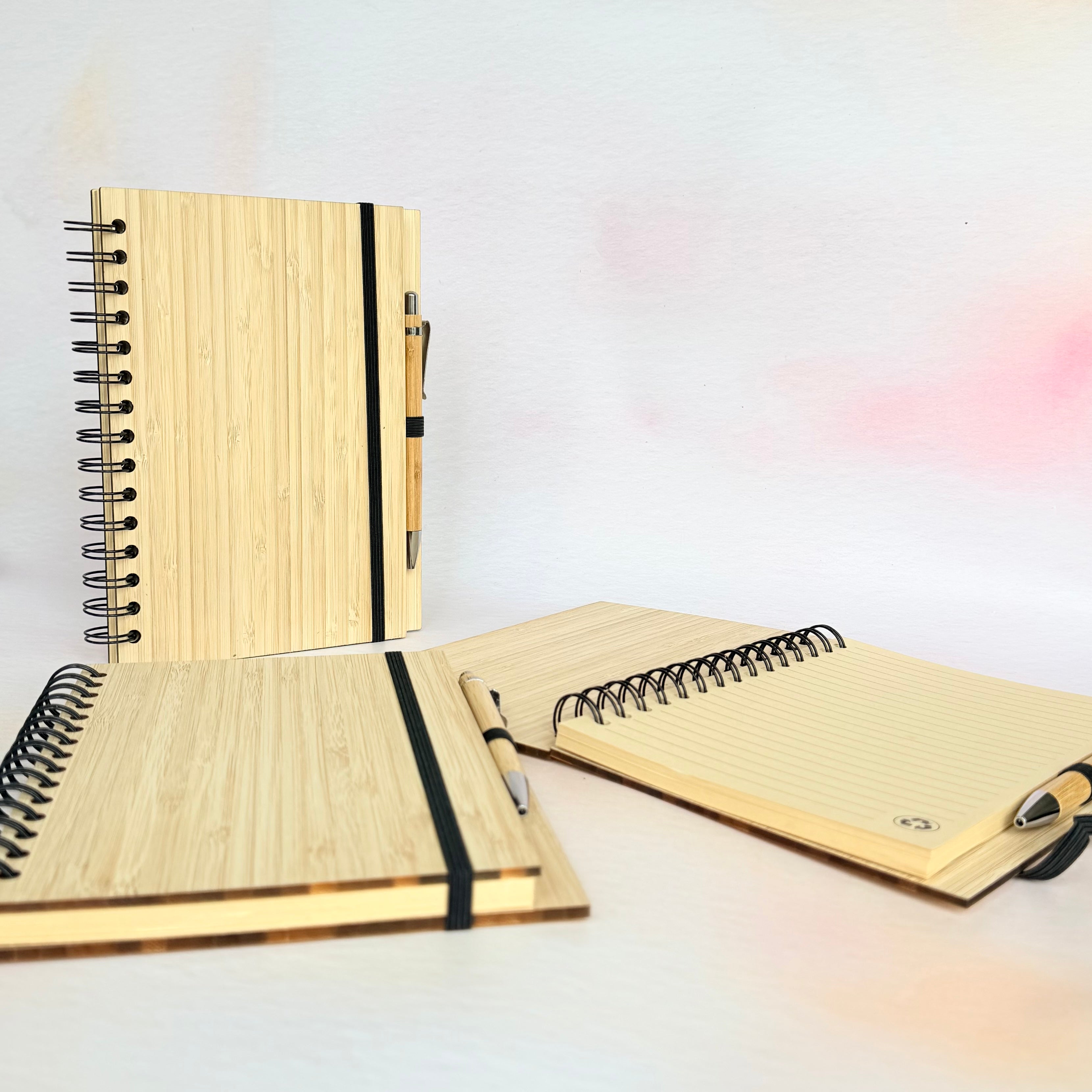 Set of three wooden notebooks with black spiral binding on a gradient background