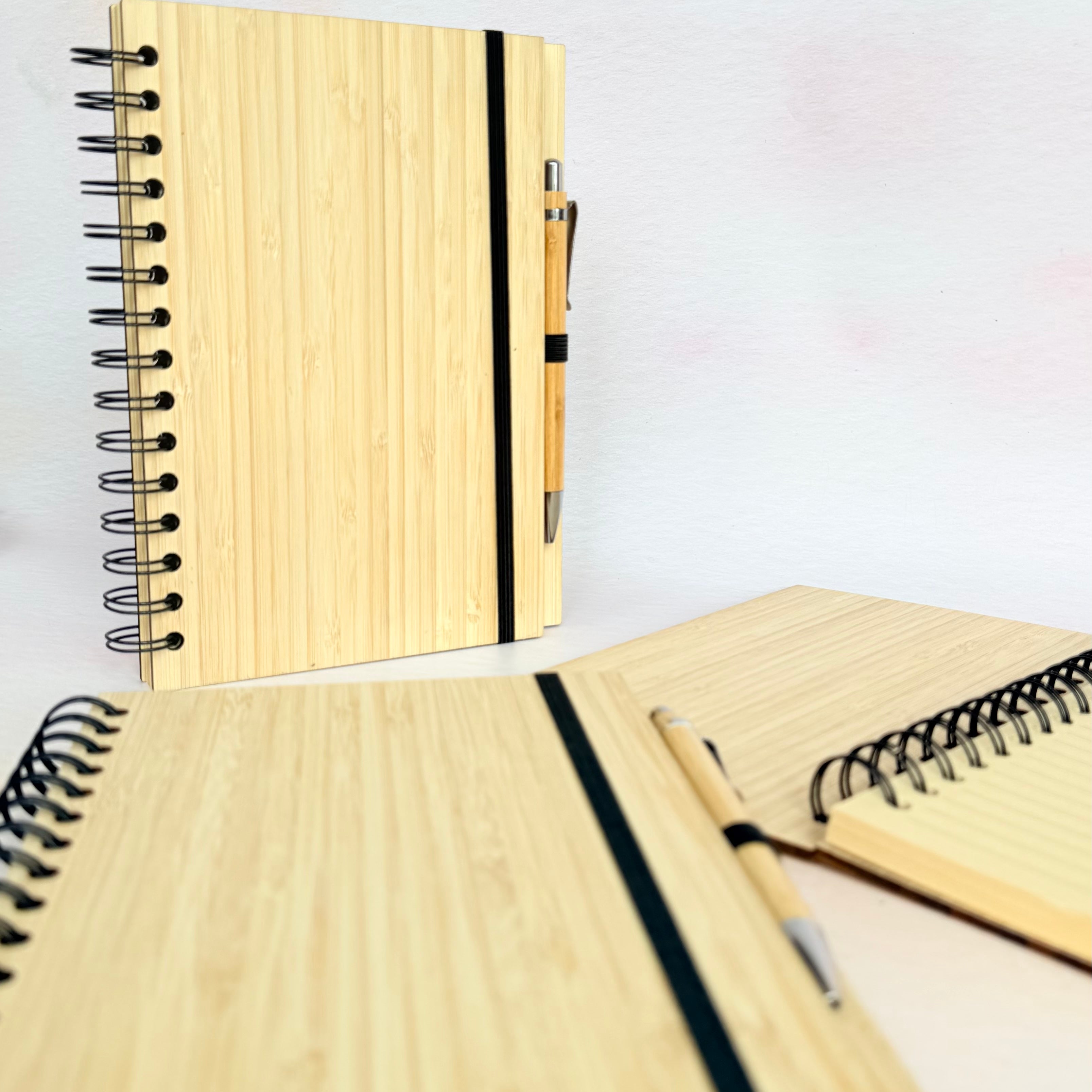 Three wooden notebooks with black ribbons on a white background