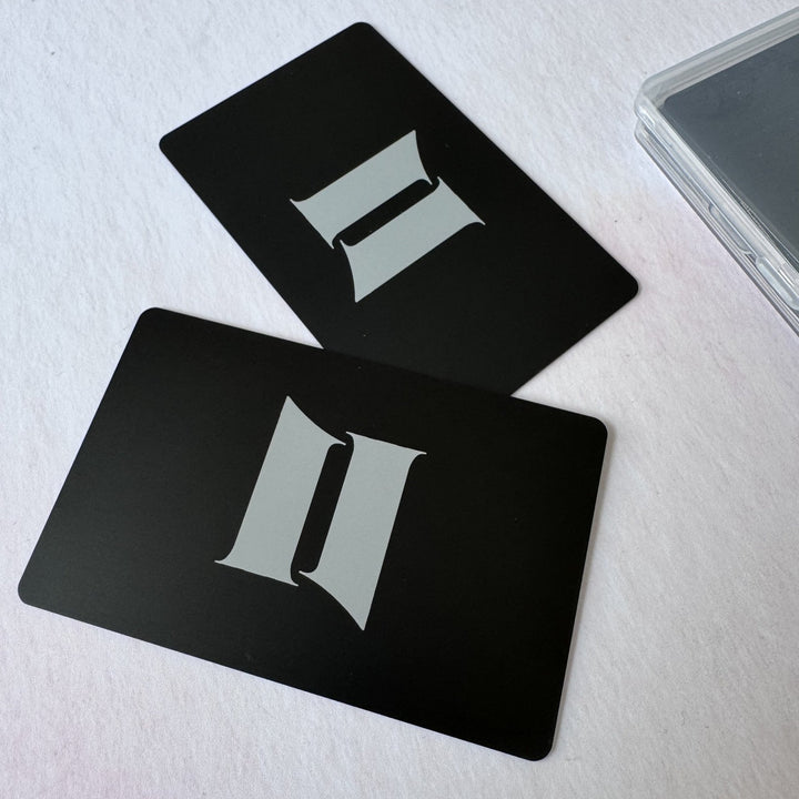Two black metal cards with engraved initials beside a clear case – personalised metal card – Etch 'N' Shine
