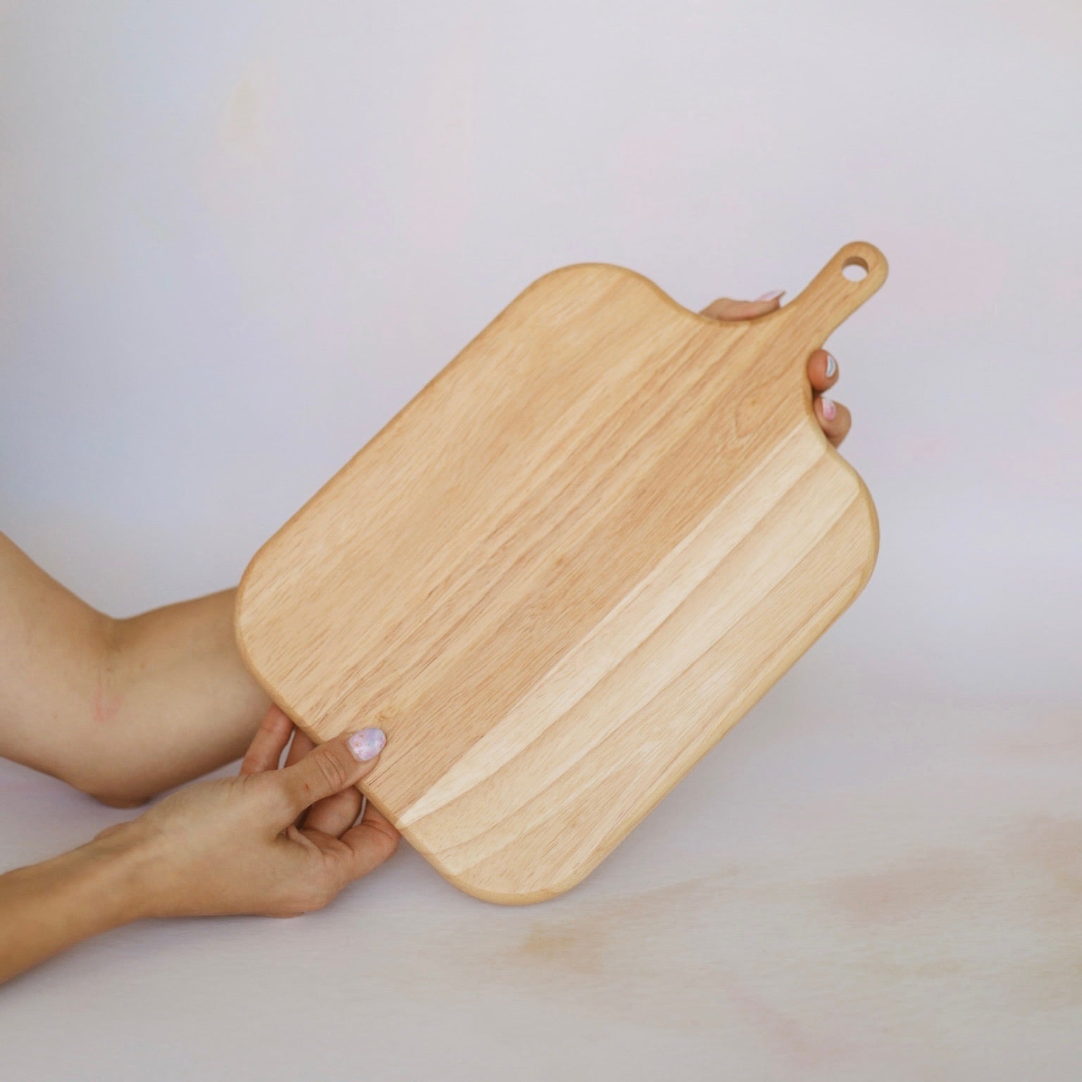 Oak chopping board with handle shown against neutral background – personalised solid oak chopping board – Etch 'N' Shine