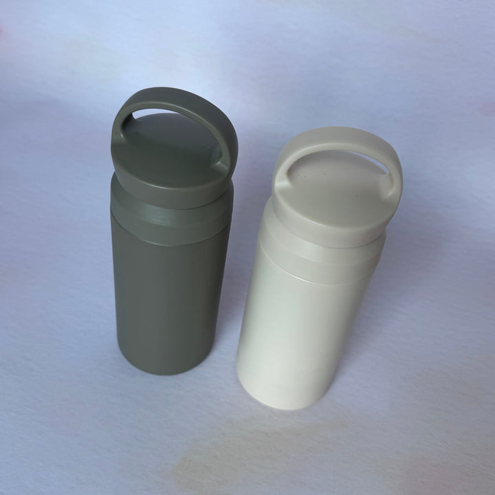Two cylindrical containers with handles on a white background