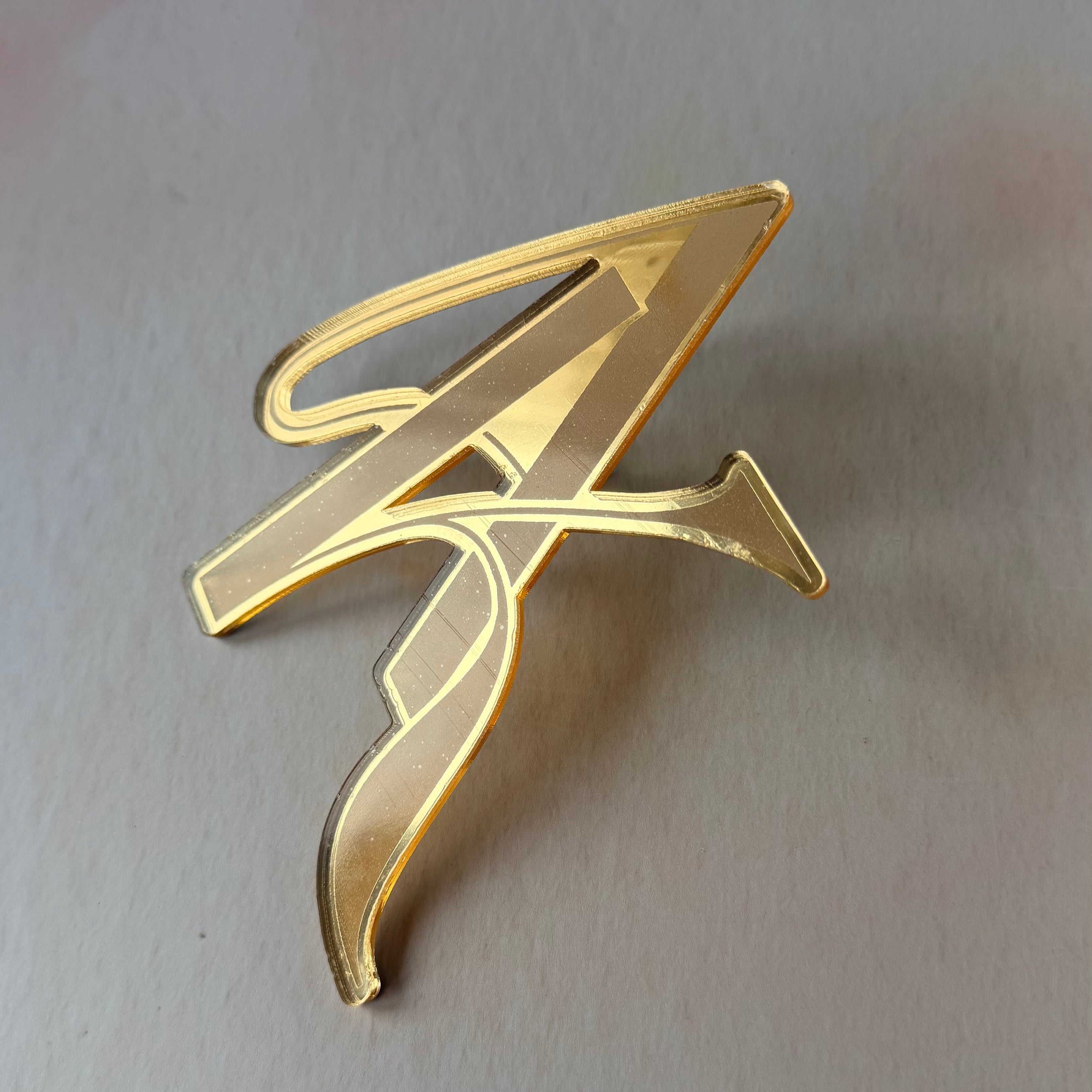 Gold decorative item on a light gray background