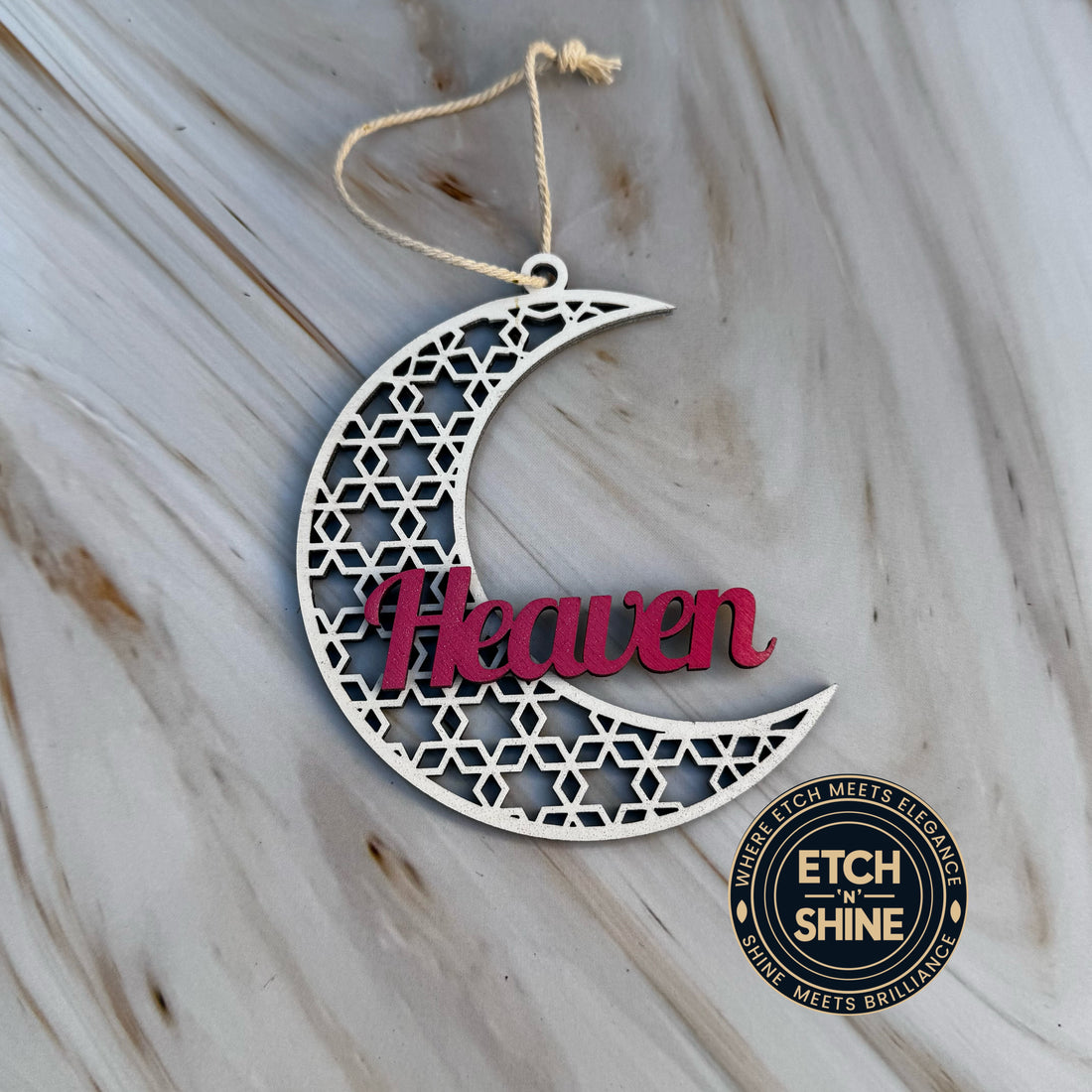 Decorative metal crescent moon with 'Heaven' text on a marble surface, featuring the brand 'Etch the Shine'.