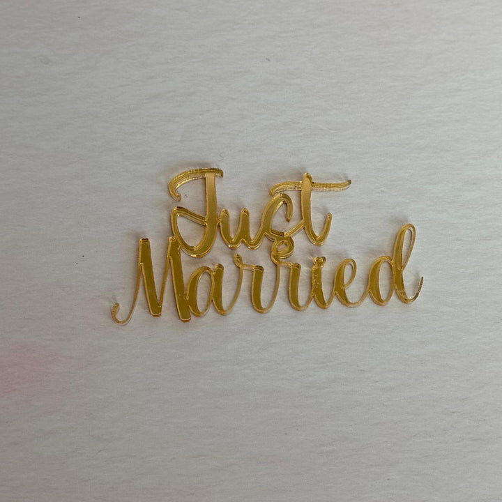 Gold 'Just Married' decoration on a textured white background