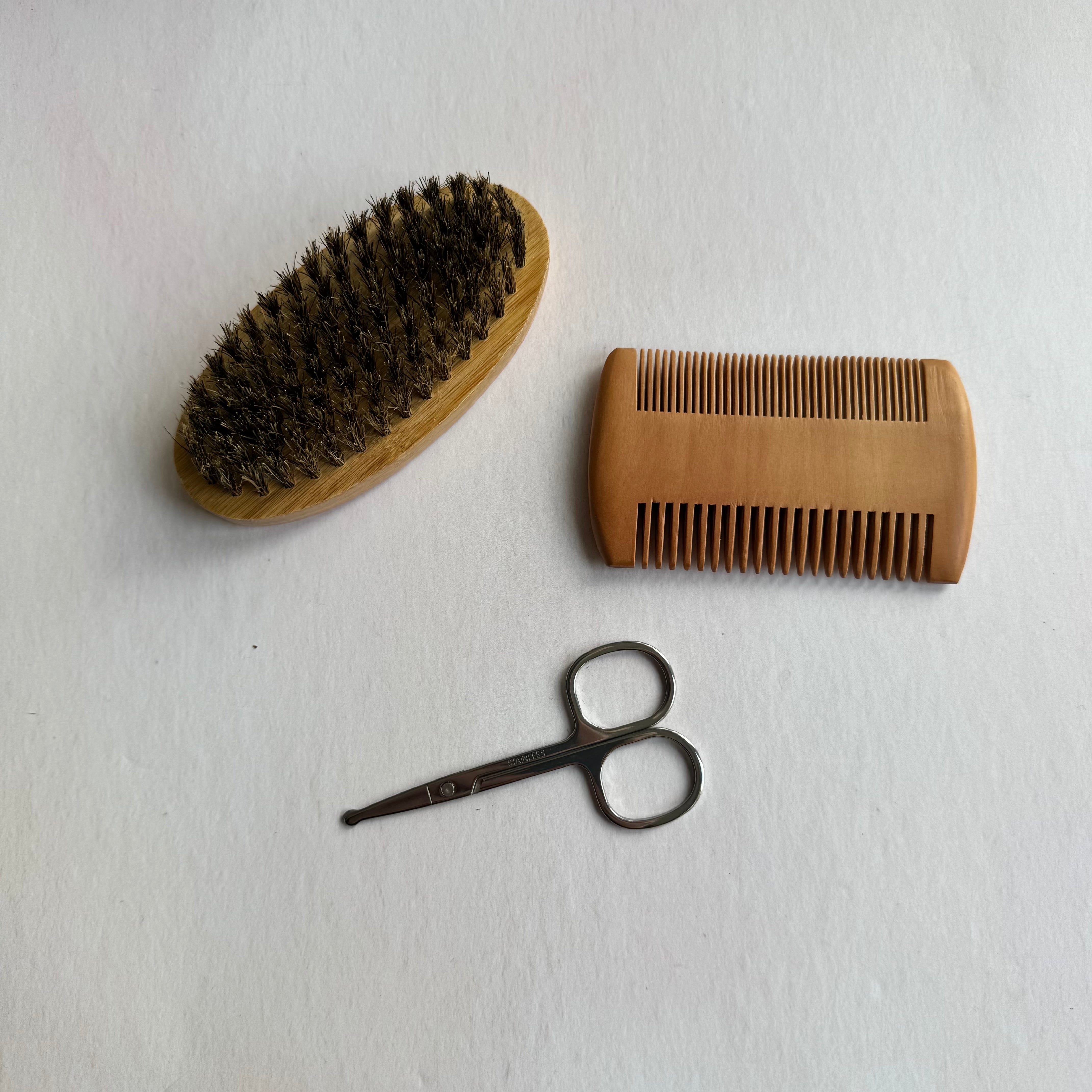Wooden brush, comb, and scissors on a white background