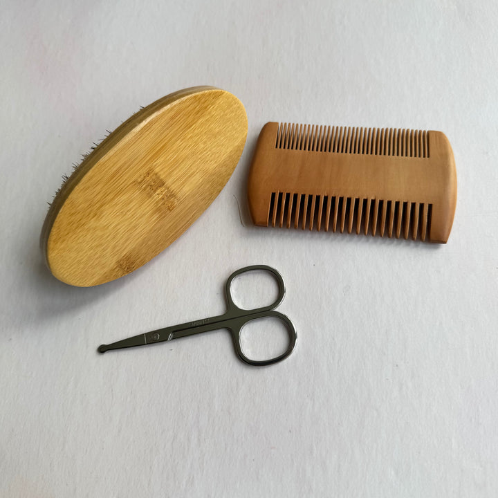 Wooden brush, comb, and scissors on a white background