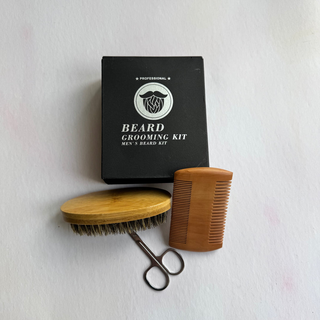 Beard grooming kit with brush, comb, and scissors on a white background