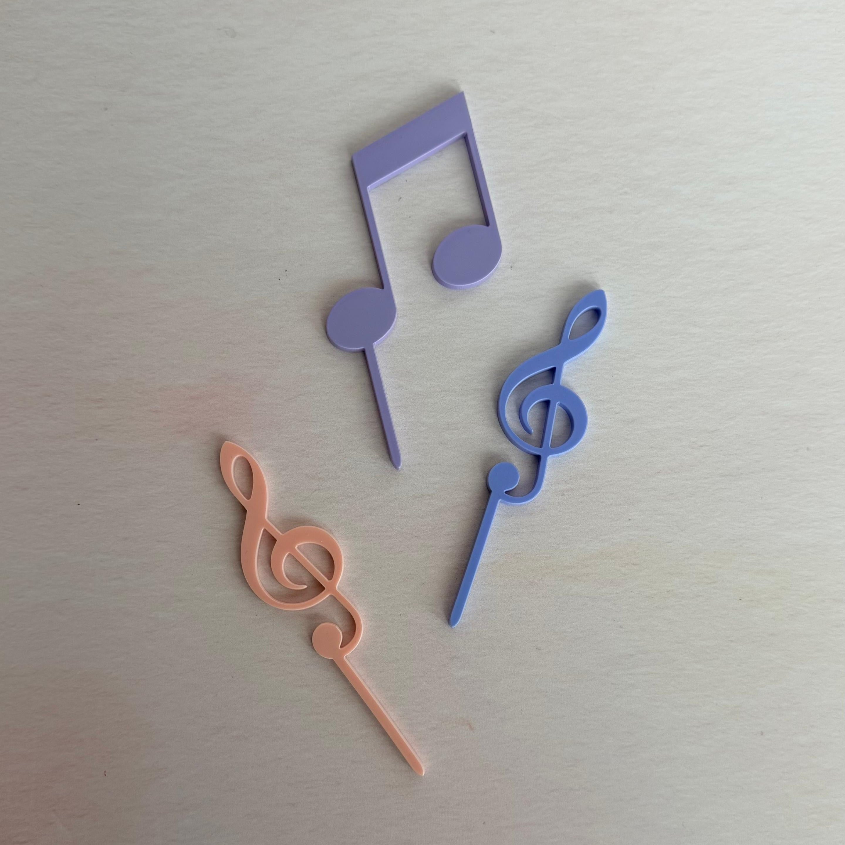 Three colorful music note-shaped objects on a light gray background