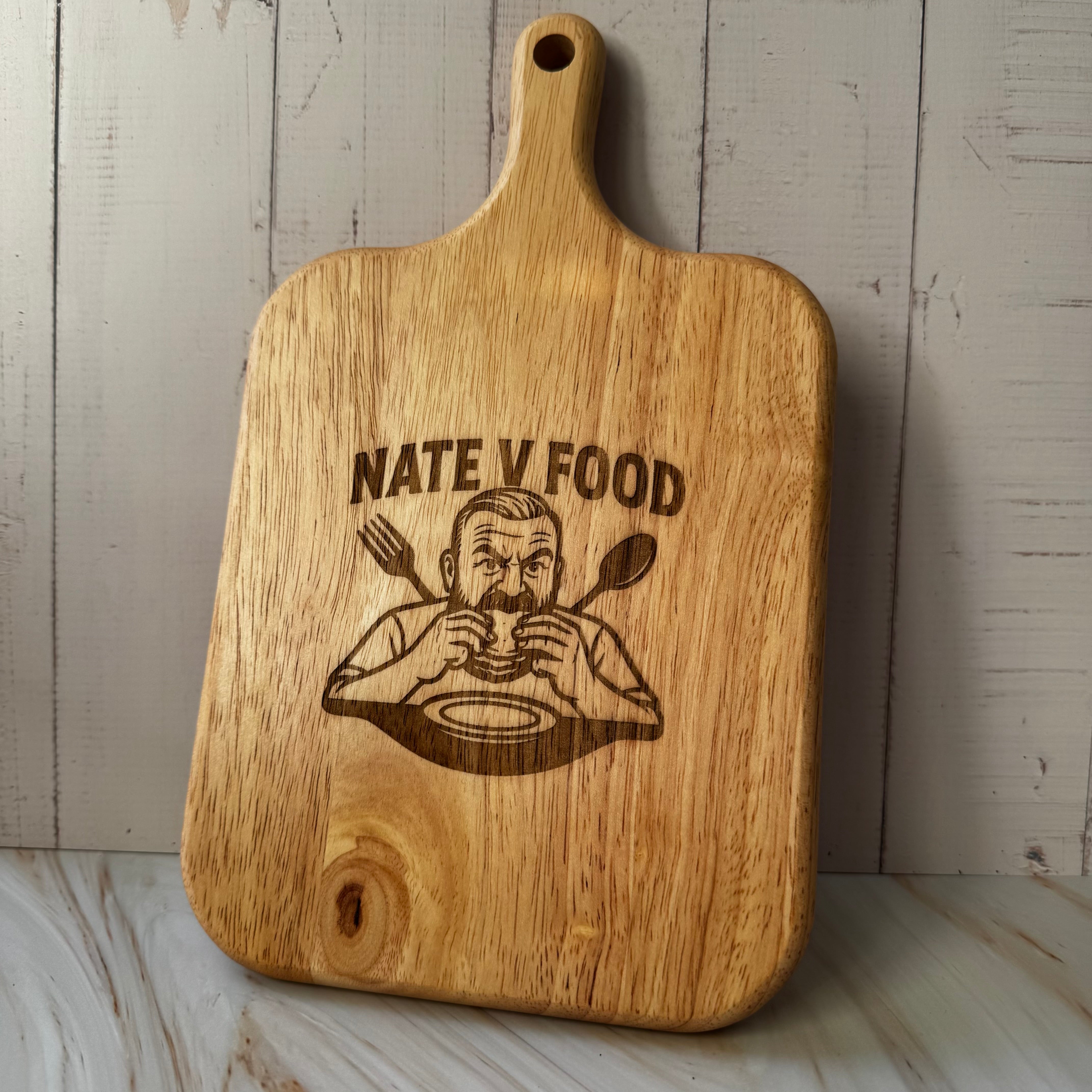 Wooden cutting board with 'Nate V Food' engraving on a wooden surface