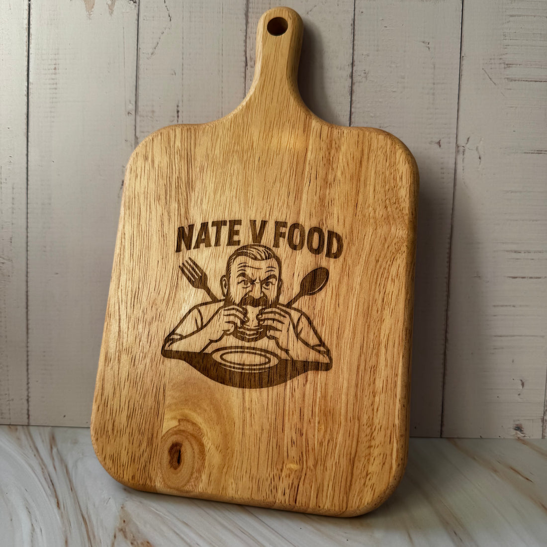 Wooden cutting board with 'Nate V Food' engraving on a wooden surface