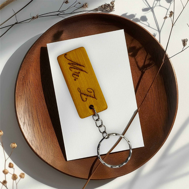Engraved bamboo keyring with custom text on a wooden tray – personalised bamboo keyring – Etch 'N' Shine