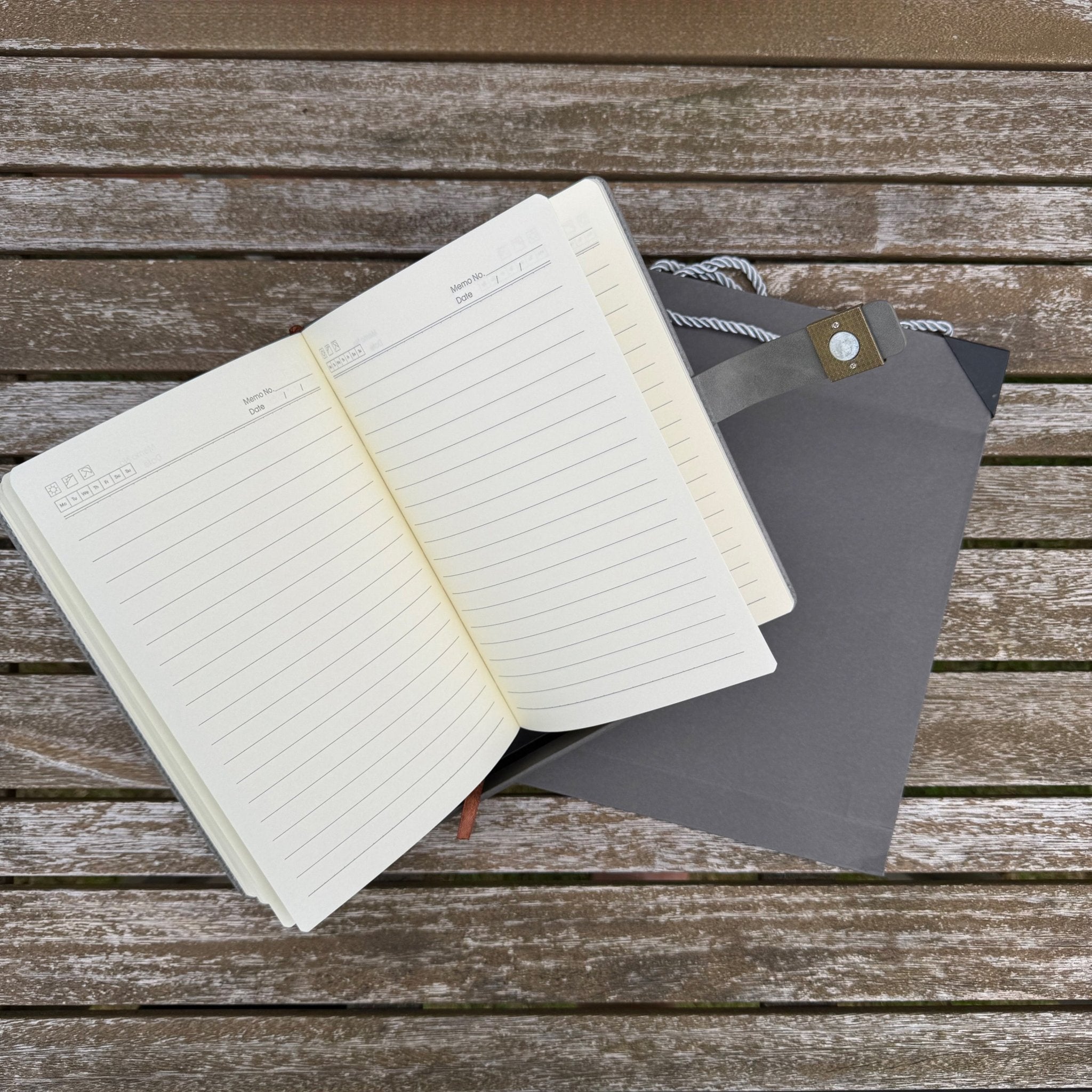 Open lined notebook resting on grey gift bag on wooden surface – personalised A5 notebook – Etch 'N' Shine