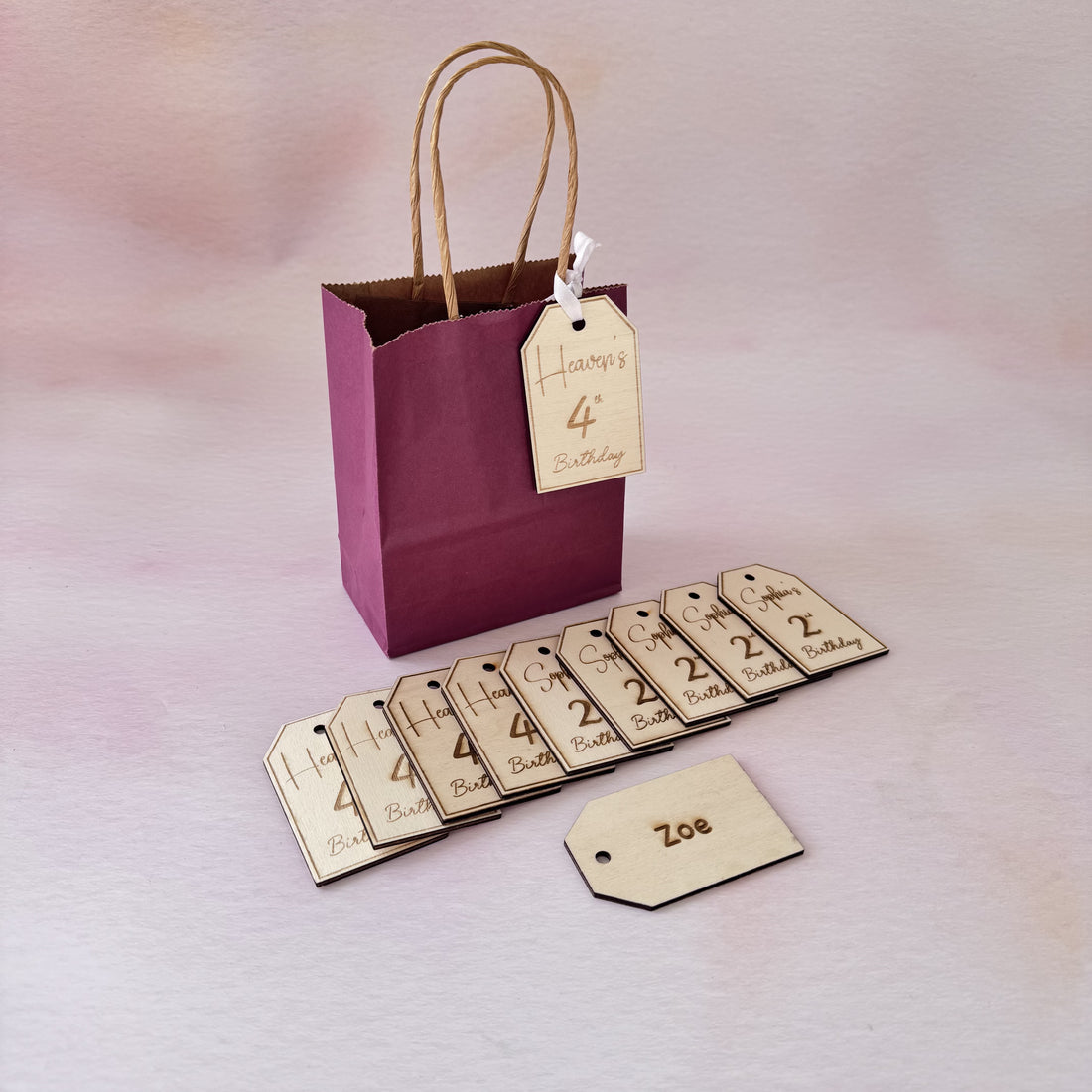 Engraved wooden gift tags with custom names on a party bag and laid flat – personalised wooden bag tags – Etch 'N' Shine