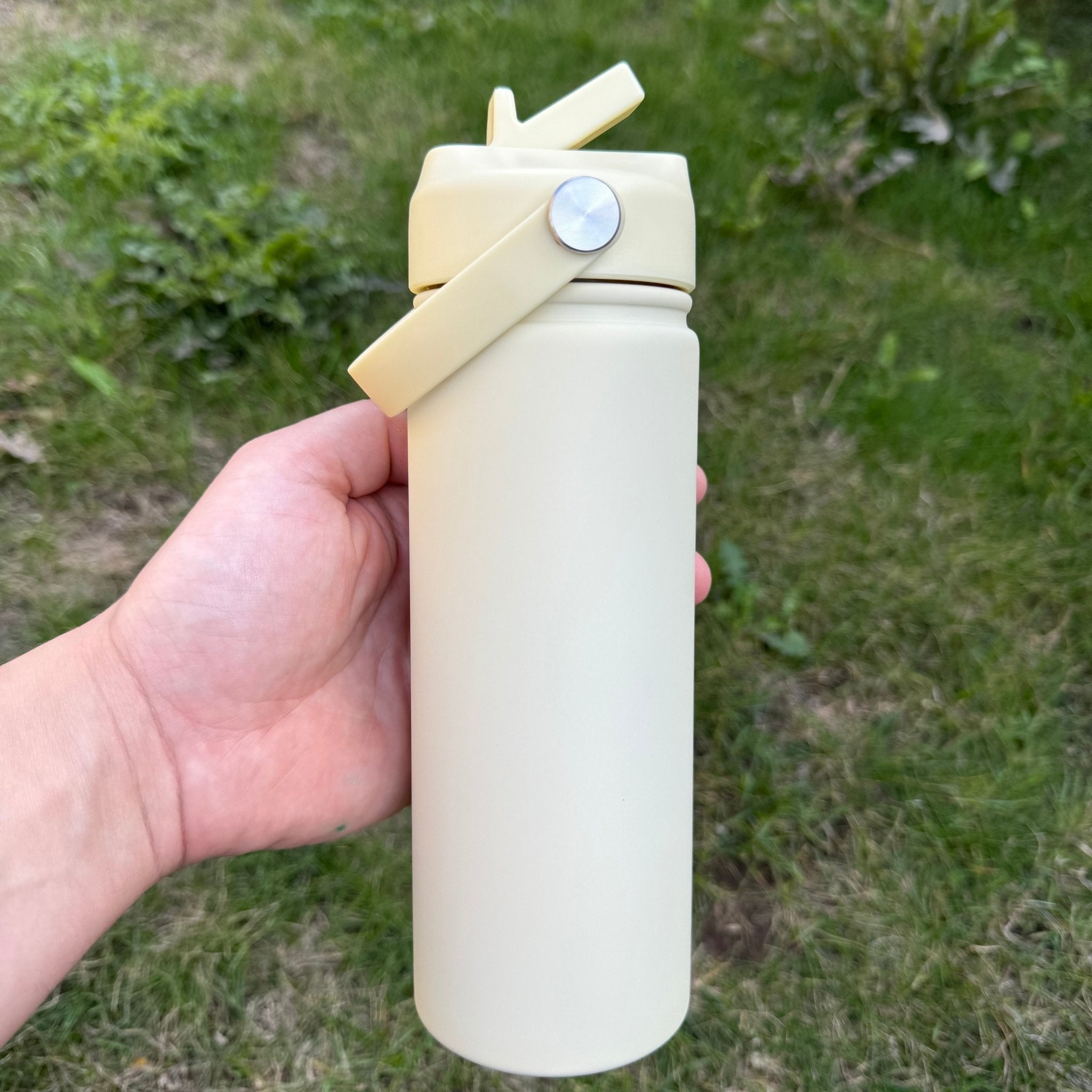 Cream insulated bottle with flip lid held outdoors – personalised steel water bottle – Etch 'N' Shine
