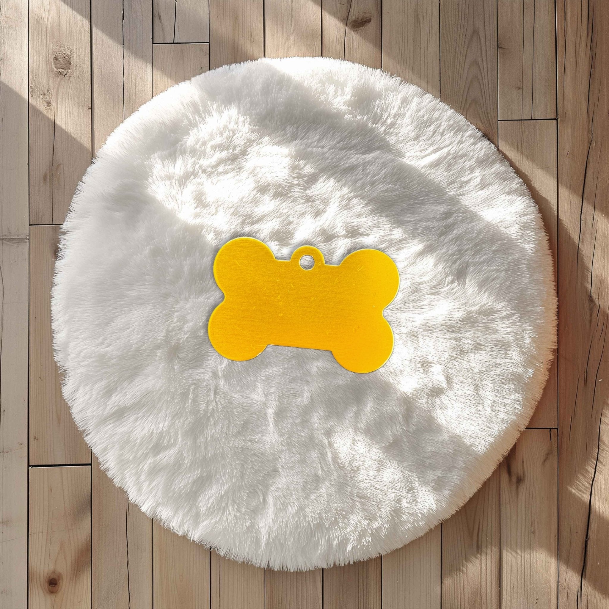 Yellow bone-shaped pet tag on a white fluffy surface – personalised engraved metal pet name tag – Etch 'N' Shine