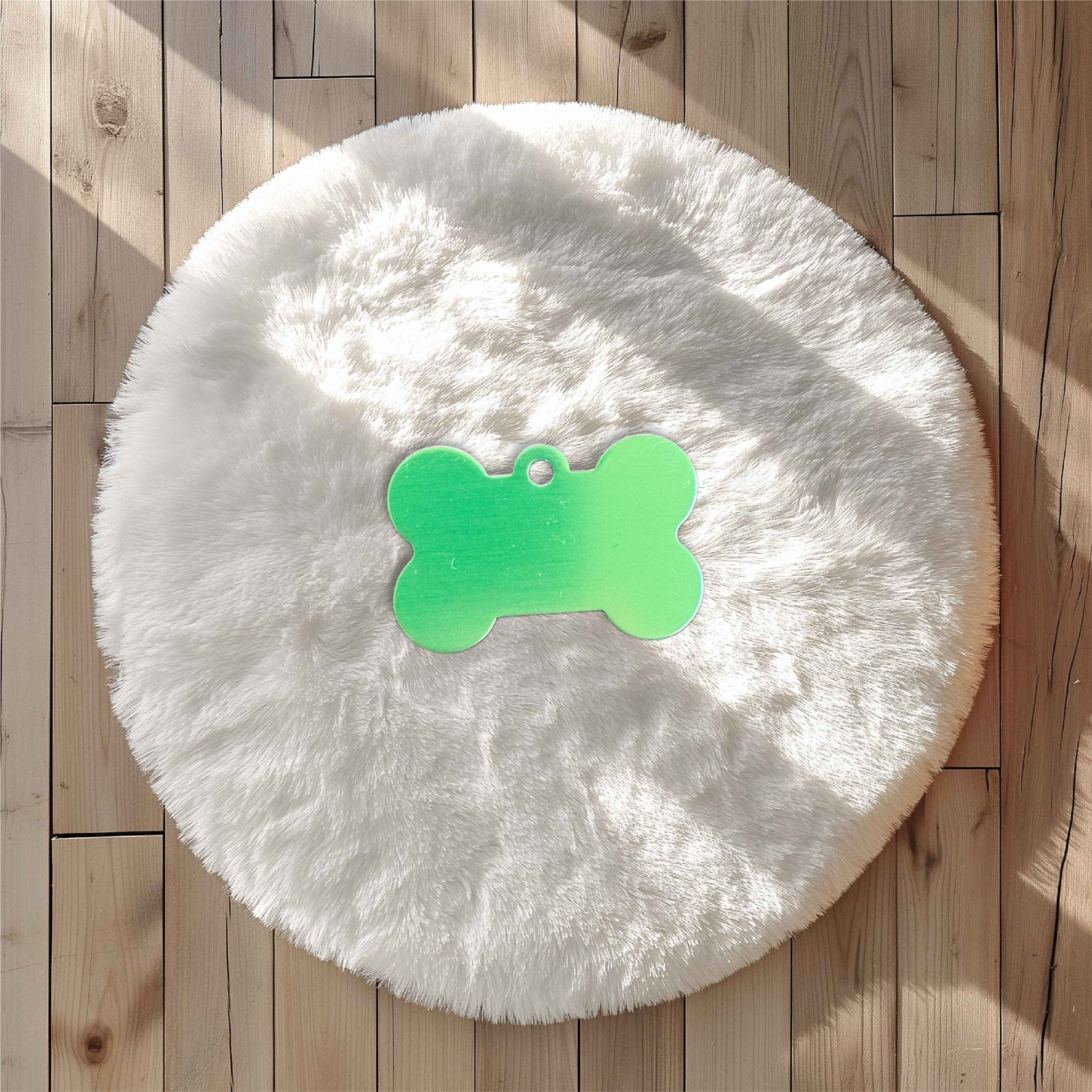 Green bone-shaped pet tag on a white fluffy surface – personalised engraved metal pet name tag – Etch 'N' Shine