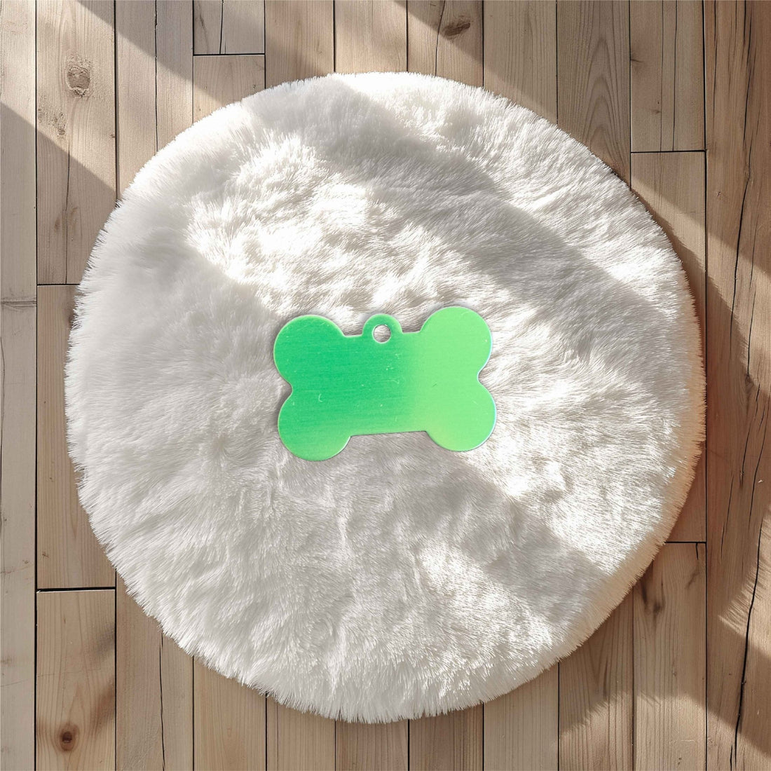 Green bone-shaped pet tag on a white fluffy surface – personalised engraved metal pet name tag – Etch 'N' Shine