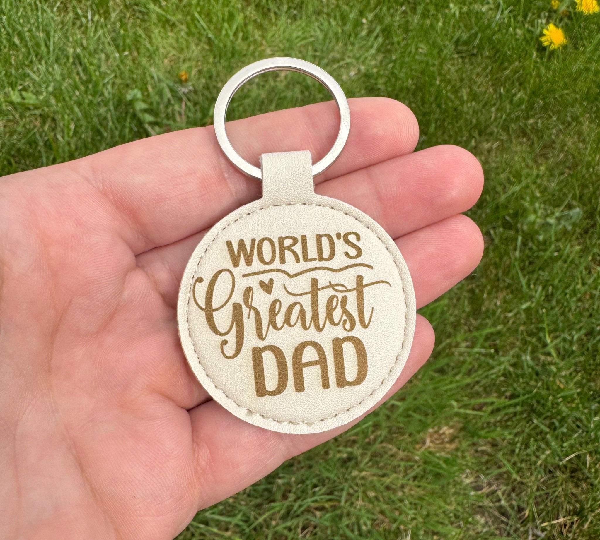 Round cream leatherette keyring with engraved message held in hand – personalised keyring – Etch 'N' Shine