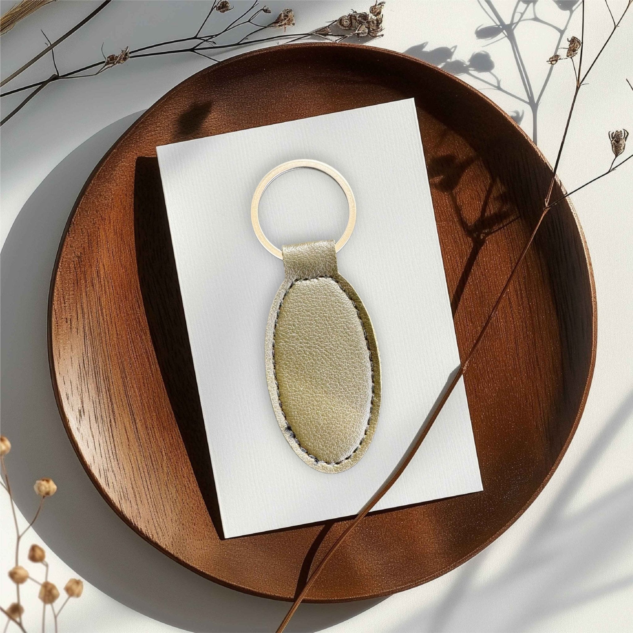 Oval gold PU leather keyring on a white card in a wooden tray – personalised engraved leather keyring – Etch 'N' Shine