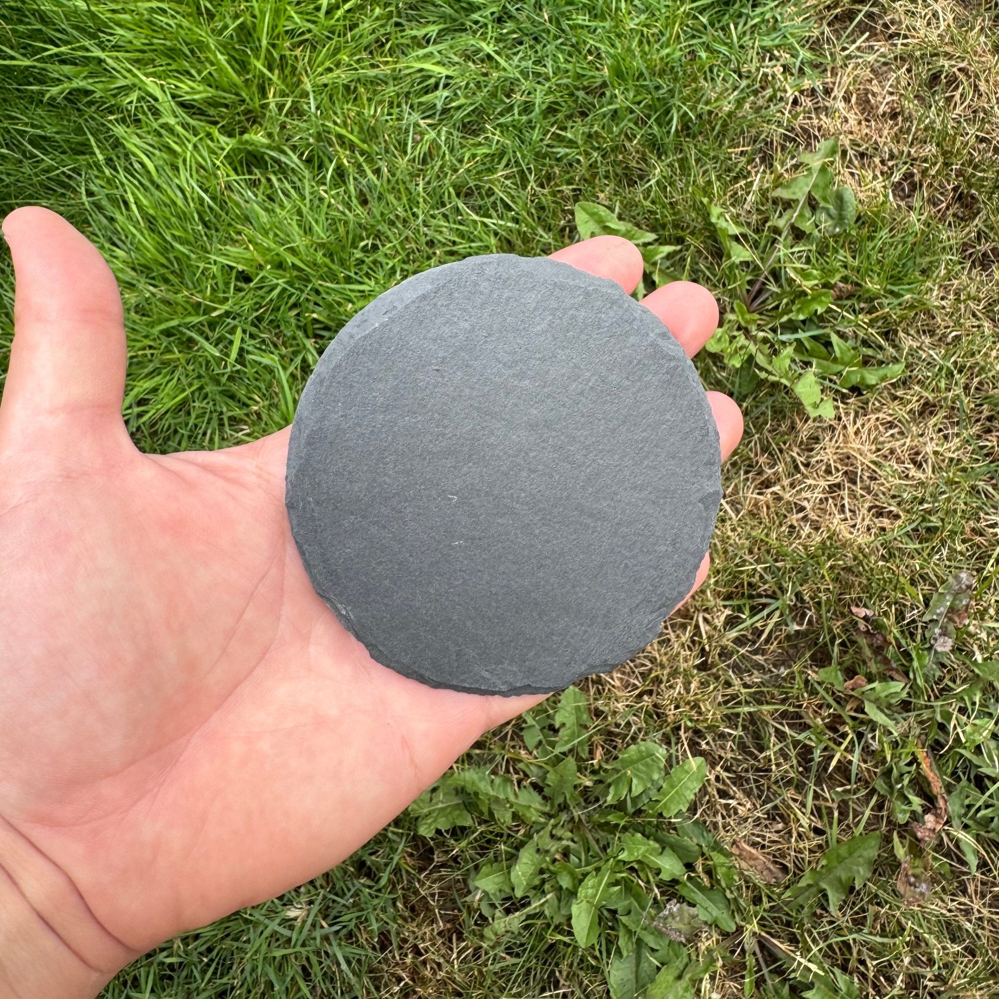 Round slate coaster shown outdoors against grass – personalised slate coaster – Etch 'N' Shine