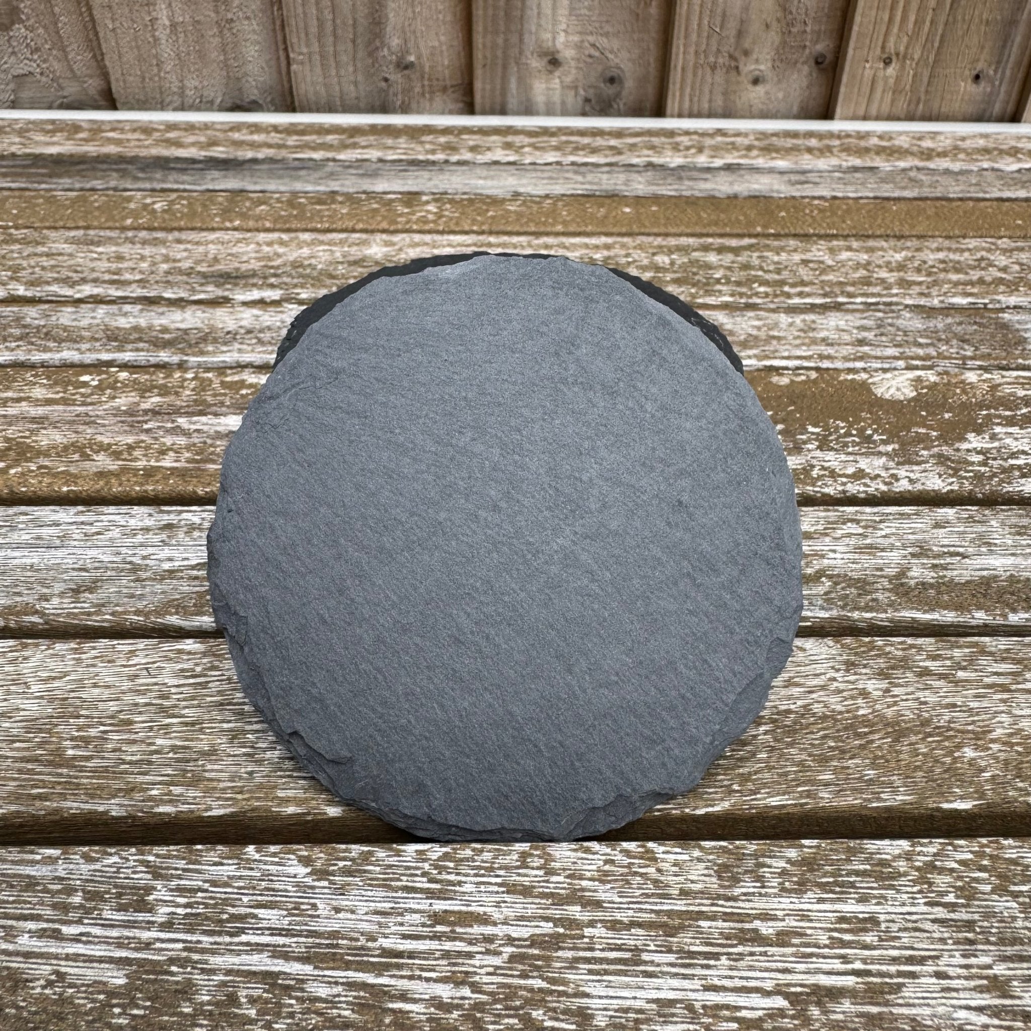Round slate coaster with natural split edges on a weathered wooden surface – personalised slate coaster – Etch 'N' Shine