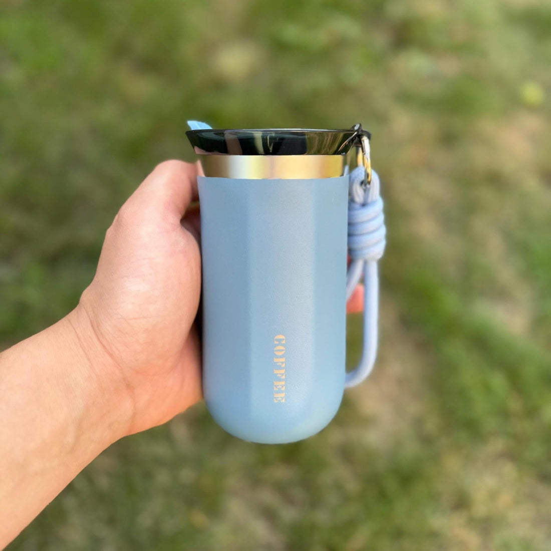 Blue insulated travel mug with custom text held outdoors – personalised steel coffee mug – Etch 'N' Shine