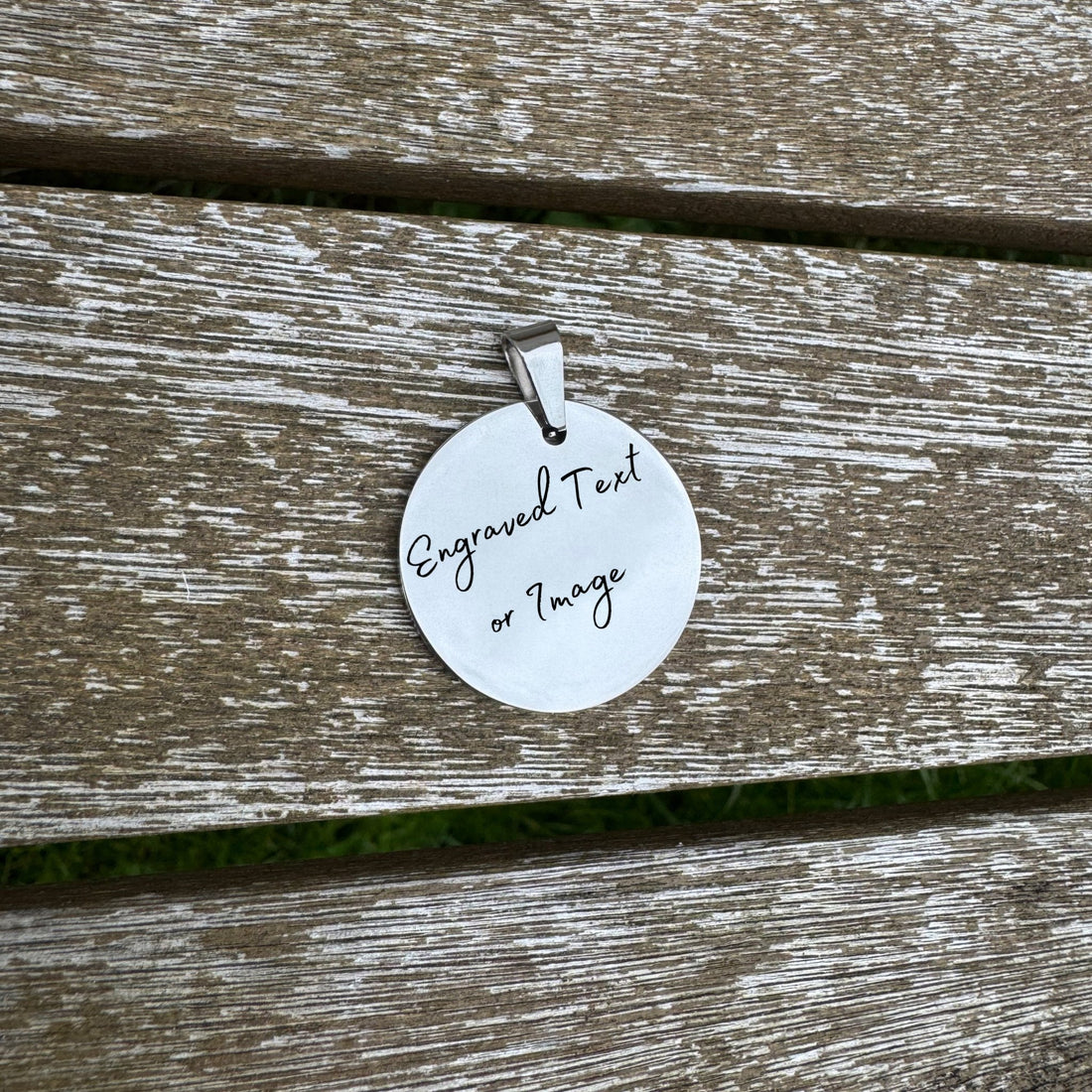 Round mirror-polished pendant with custom text on wooden surface – personalised stainless steel pendant – Etch 'N' Shine