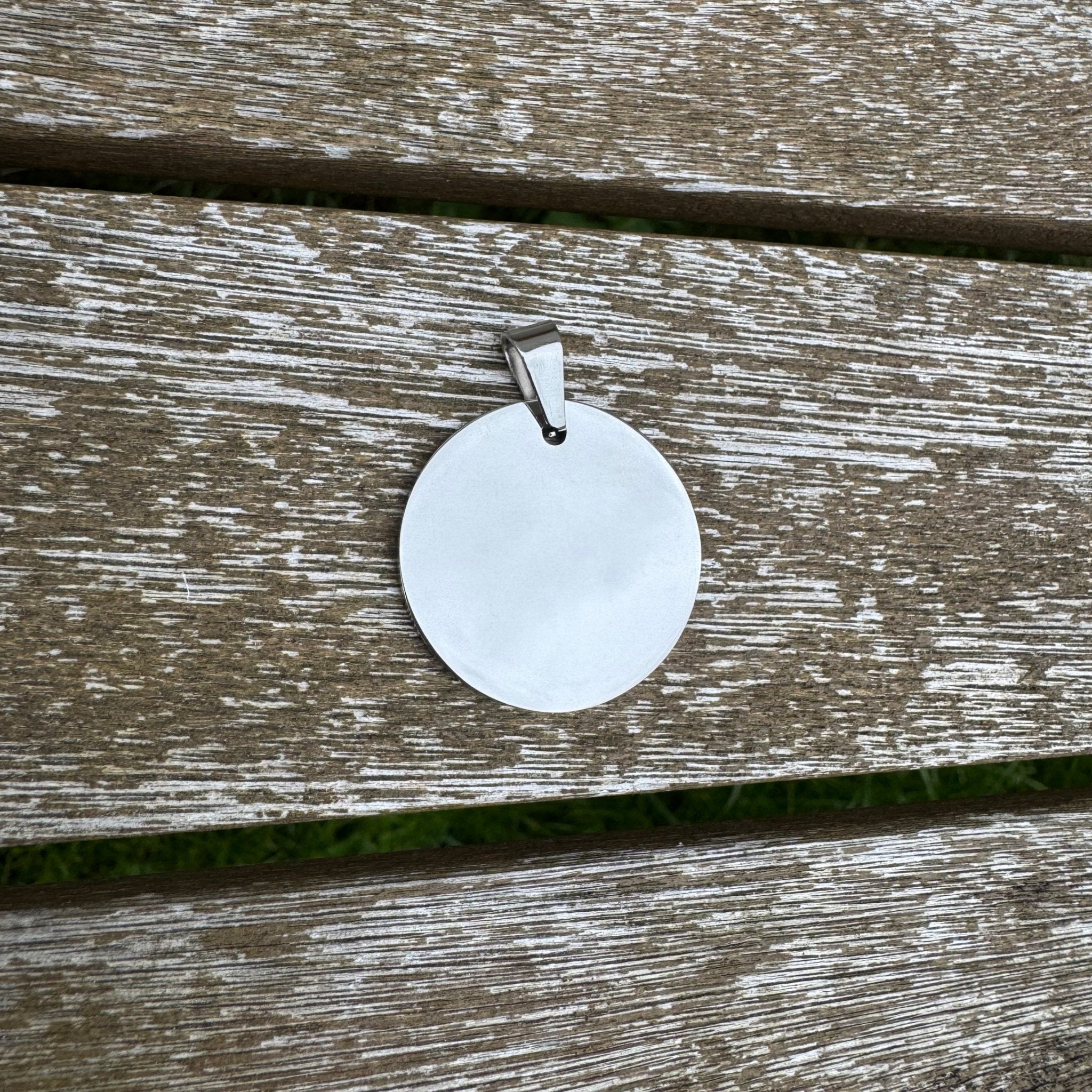 Round mirror-polished pendant on a weathered wooden surface – personalised stainless steel pendant – Etch 'N' Shine