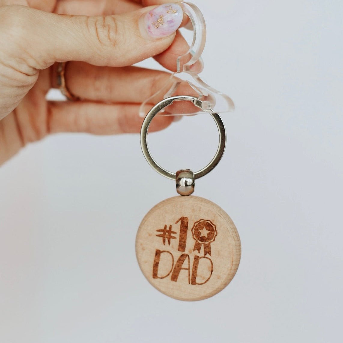 Round wooden keyring with engraved text held in hand – personalised wooden keyring – Etch 'N' Shine