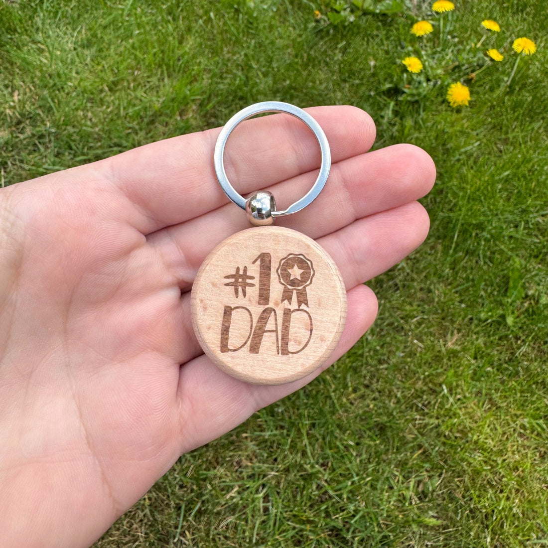 Round wooden keyring with custom text held in hand – engraved wooden keyring – Etch 'N' Shine