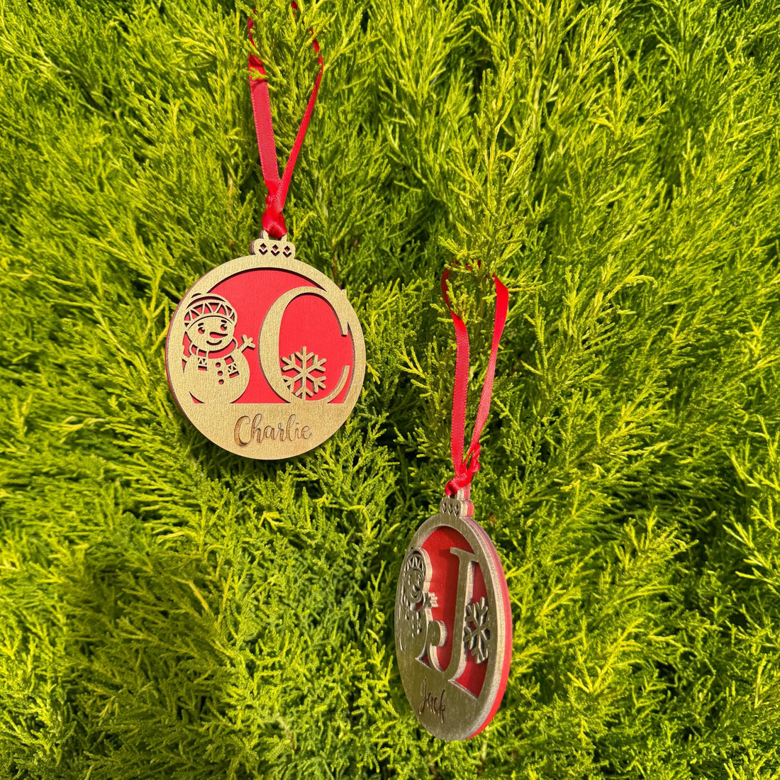 Two wooden baubles with custom initials and names on red ribbon – engraved Christmas ornaments – Etch 'N' Shine