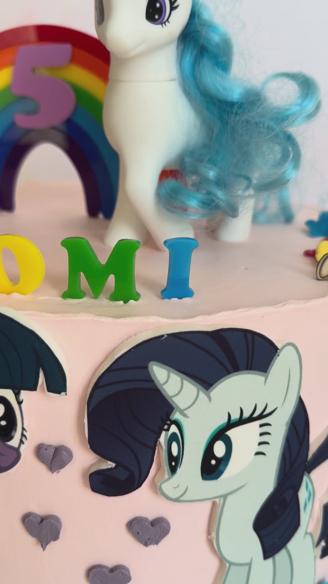 Video of the rainbow arch and NAOMI topper set on a cake, second view – Etch 'N' Shine