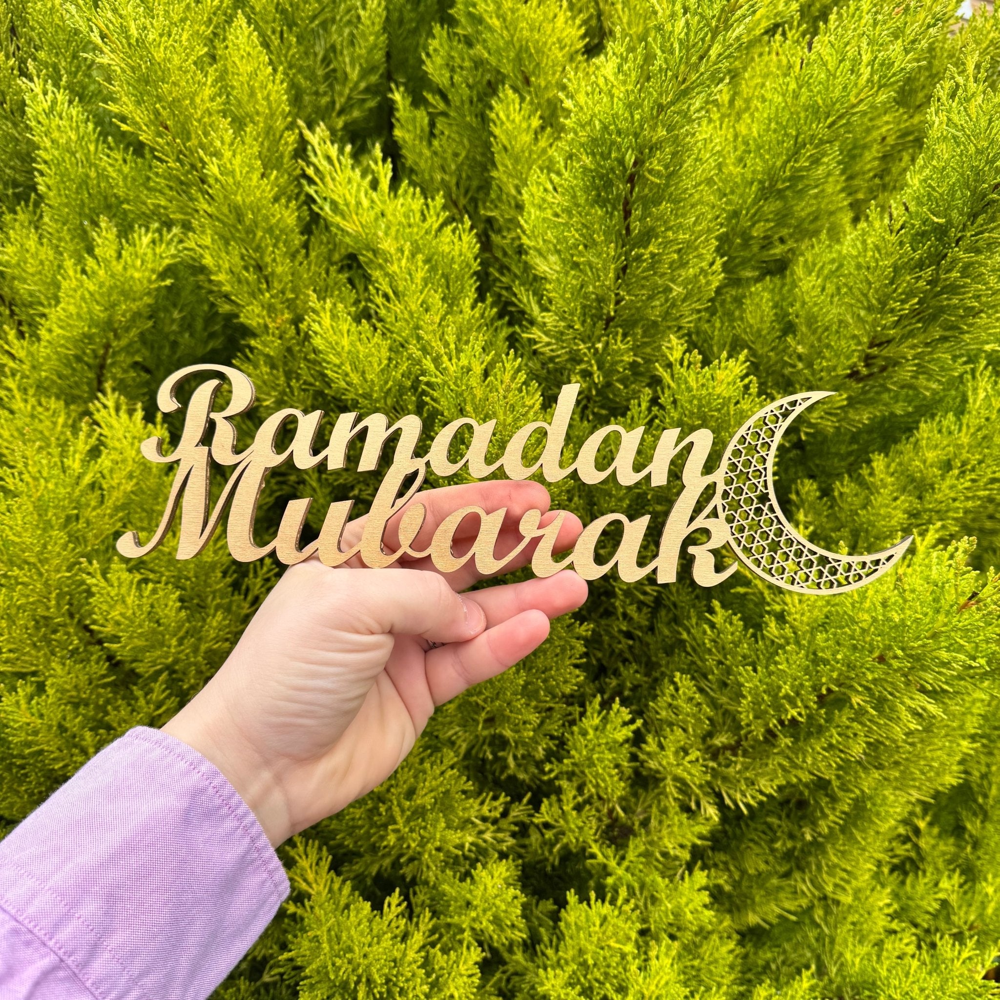Laser-cut Ramadan Mubarak wooden sign with crescent moon detail against green foliage – wood sign – Etch 'N' Shine